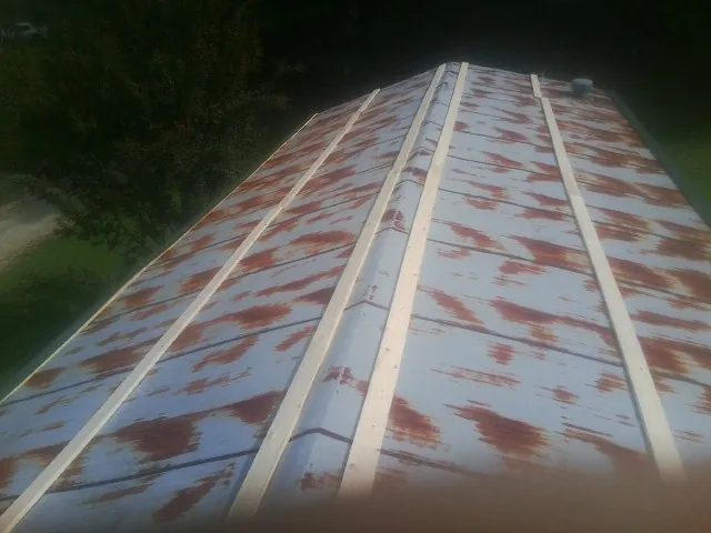 Rusted metal roof panels with new wood purlins before replacement — Storm Damage Roof Repair in Waldport by Roofing Brothers