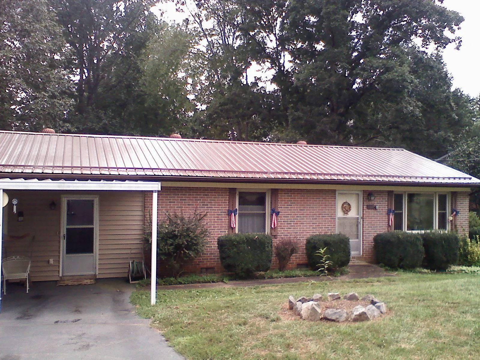 Bronze metal roof and carport on a brick ranch home — Roof Repair work by our crew in Waldport